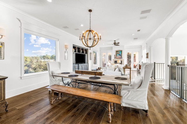 dining space with ornate columns, dark hardwood / wood-style flooring, ceiling fan with notable chandelier, and ornamental molding