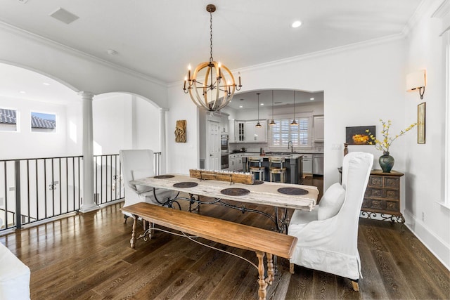 dining space featuring dark hardwood / wood-style flooring, an inviting chandelier, crown molding, and sink