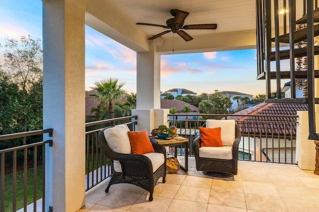 balcony at dusk featuring ceiling fan