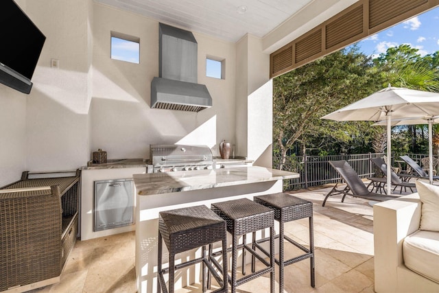 view of patio with a bar, area for grilling, and exterior kitchen