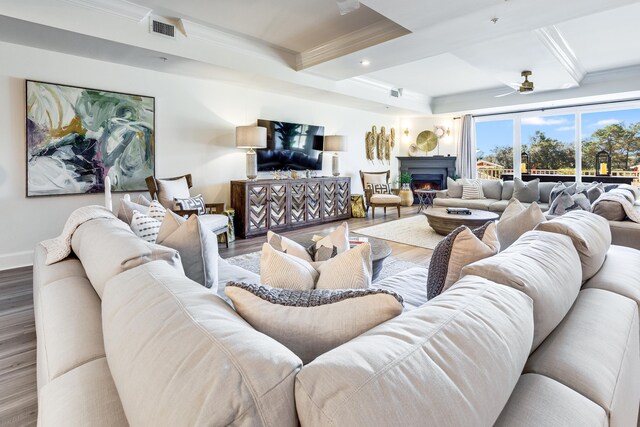 living room with hardwood / wood-style floors, ceiling fan, beam ceiling, and ornamental molding