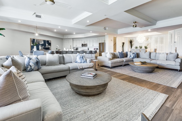 living room with crown molding, ceiling fan, and wood-type flooring