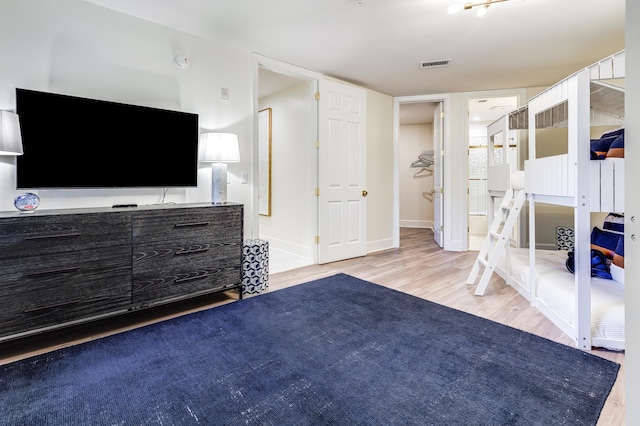 bedroom with light hardwood / wood-style floors and ensuite bath