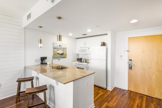 kitchen featuring white appliances, white cabinets, sink, dark hardwood / wood-style floors, and kitchen peninsula