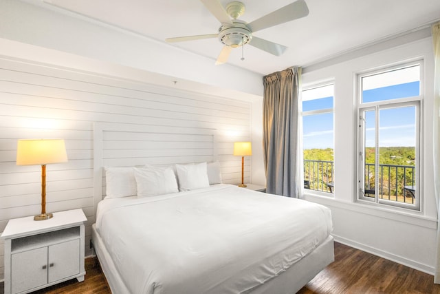 bedroom featuring dark hardwood / wood-style floors, ceiling fan, and wood walls