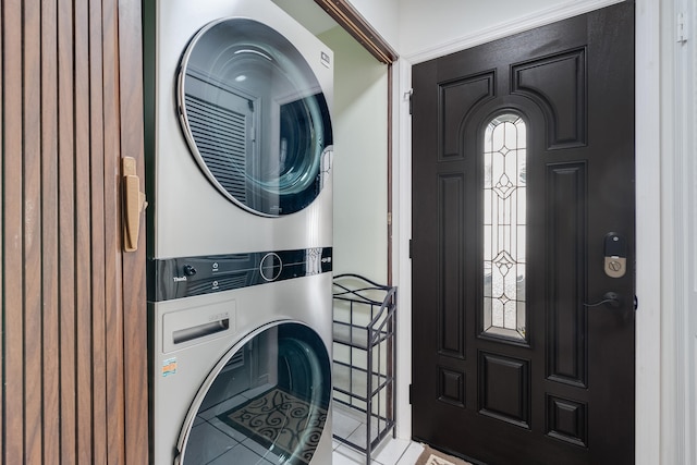 washroom with light tile patterned flooring and stacked washer and clothes dryer