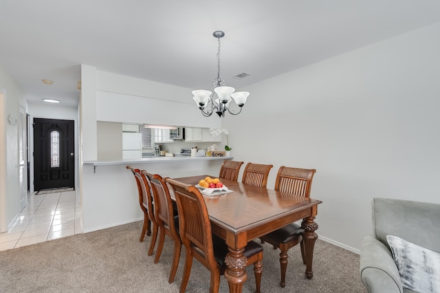 dining space with light colored carpet and an inviting chandelier