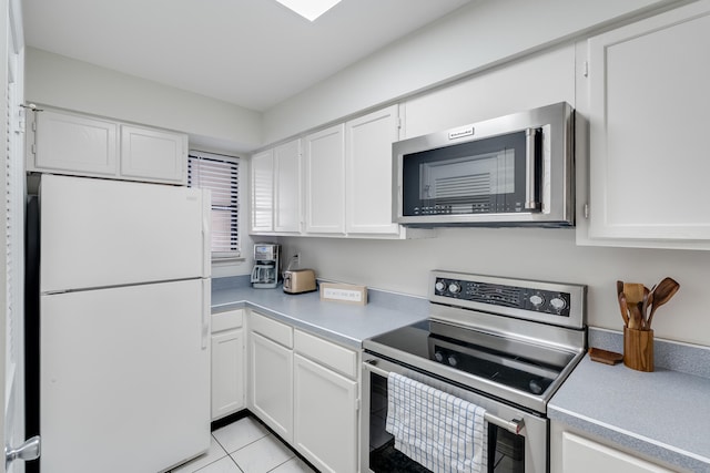 kitchen with white cabinets, stainless steel appliances, and light tile patterned flooring