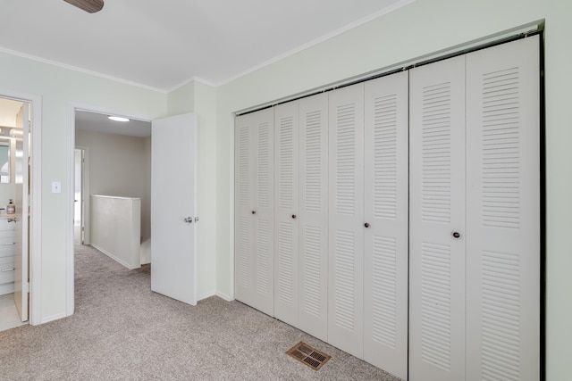 unfurnished bedroom featuring light carpet, a closet, and ornamental molding