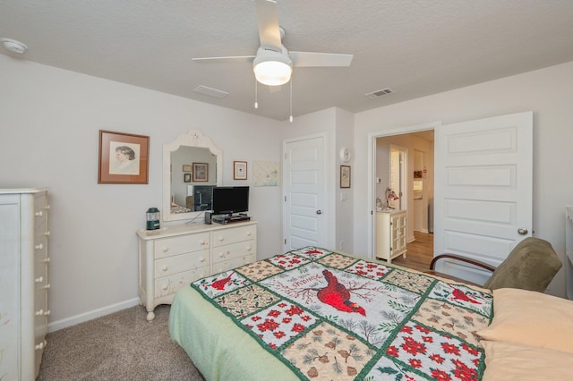 carpeted bedroom featuring a textured ceiling and ceiling fan