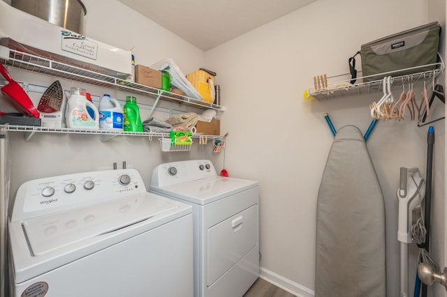 laundry room with hardwood / wood-style floors and washing machine and dryer