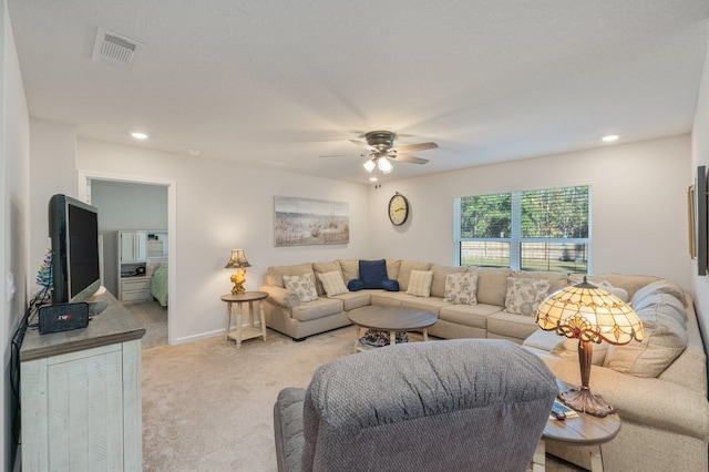 carpeted living room with ceiling fan