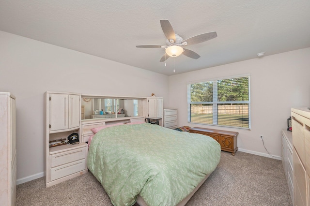 carpeted bedroom featuring ceiling fan and a textured ceiling