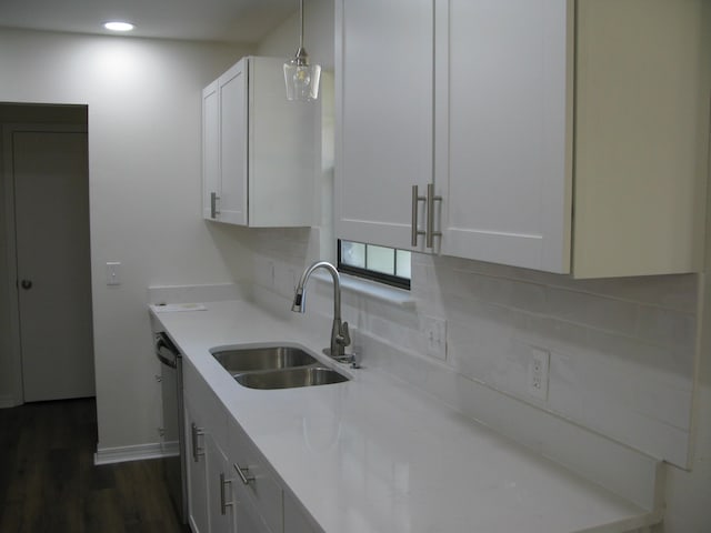 kitchen featuring white cabinets, decorative light fixtures, sink, and dark wood-type flooring