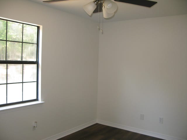 spare room with dark hardwood / wood-style floors and ceiling fan