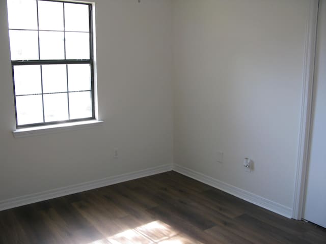 unfurnished room featuring dark hardwood / wood-style flooring