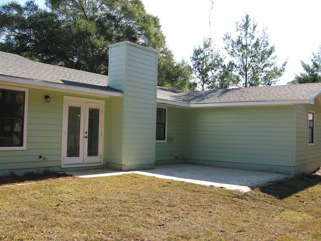 rear view of property with a lawn, a patio, and french doors