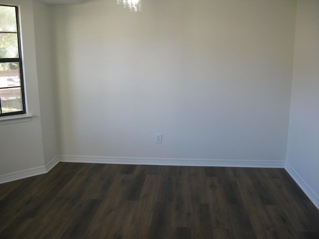 unfurnished room with dark wood-type flooring