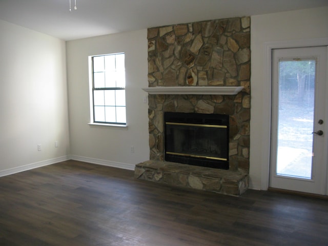 unfurnished living room featuring a fireplace and dark hardwood / wood-style floors