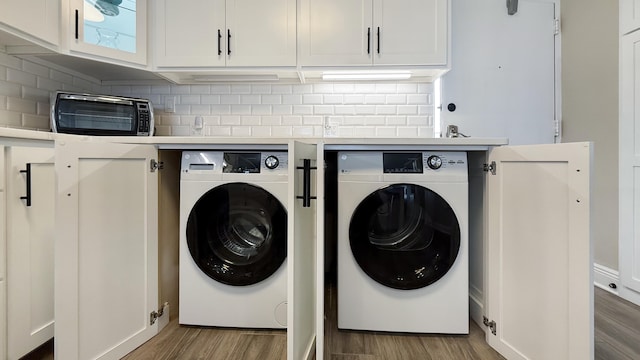 clothes washing area featuring light wood-type flooring and separate washer and dryer