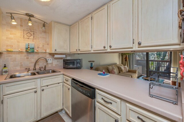 kitchen with a textured ceiling, backsplash, stainless steel dishwasher, and sink