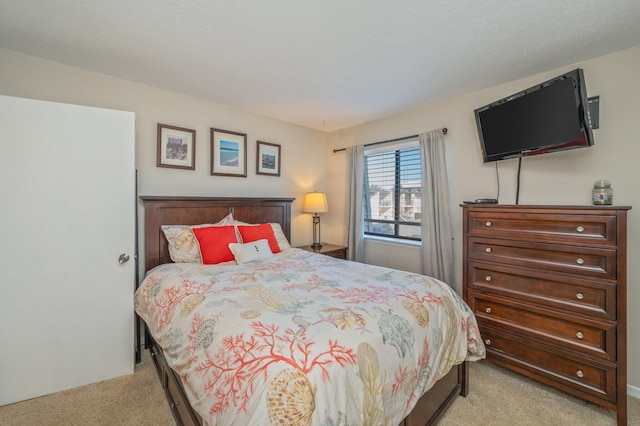 bedroom featuring light colored carpet and a textured ceiling