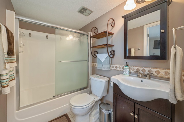 full bathroom featuring tile patterned flooring, bath / shower combo with glass door, a textured ceiling, toilet, and vanity