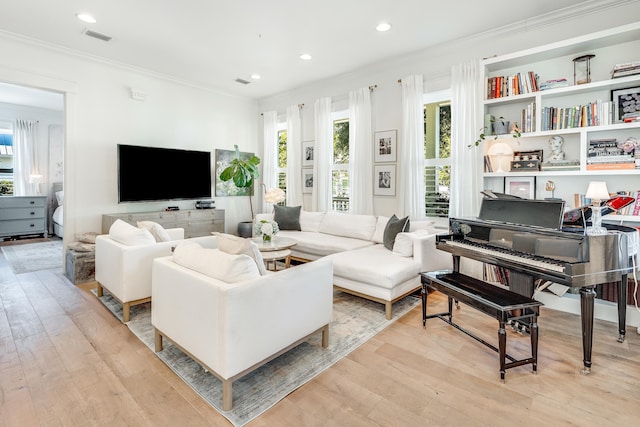 living room with crown molding and light hardwood / wood-style flooring