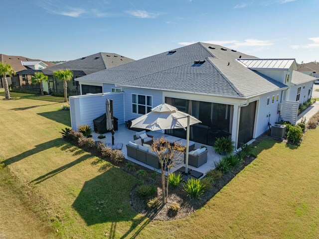 rear view of house with an outdoor living space, a yard, a patio, and central AC unit