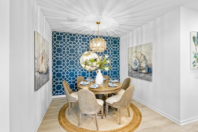 dining room featuring a notable chandelier and light hardwood / wood-style flooring