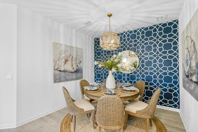 dining area featuring light wood-type flooring and a chandelier