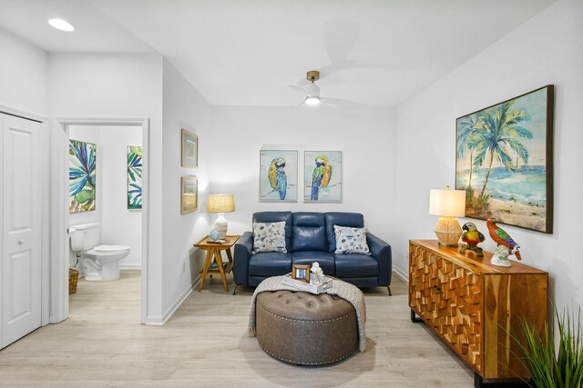 living area featuring light hardwood / wood-style flooring and ceiling fan