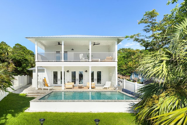 back of house with ceiling fan, a patio area, a balcony, and french doors