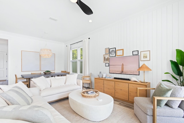 living area with crown molding and light wood-type flooring