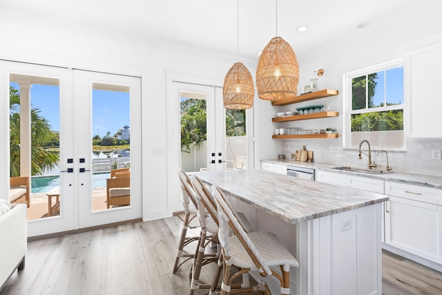 kitchen featuring tasteful backsplash, french doors, dishwasher, and a sink