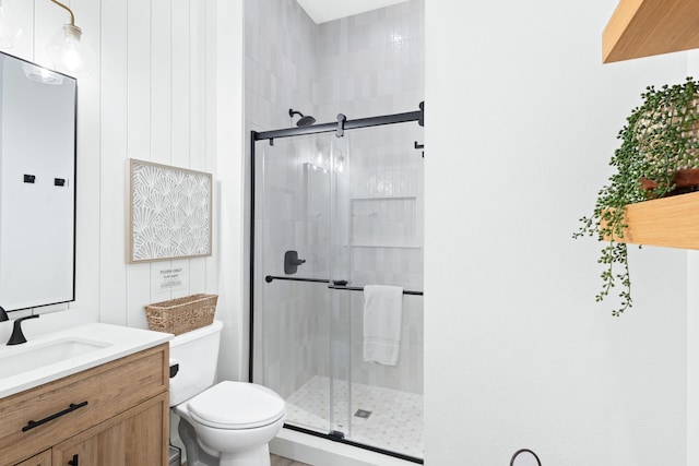 bathroom with vanity, a shower stall, and toilet