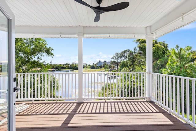 deck with a water view and ceiling fan