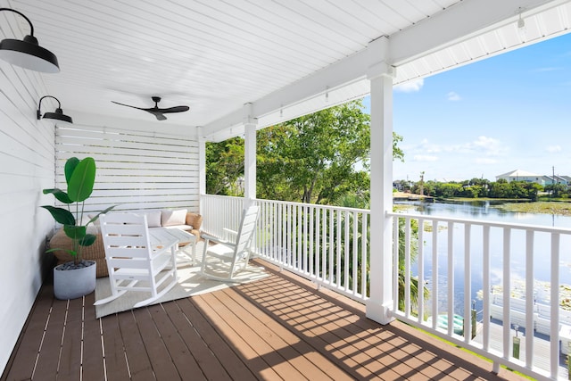 wooden terrace featuring ceiling fan and a water view