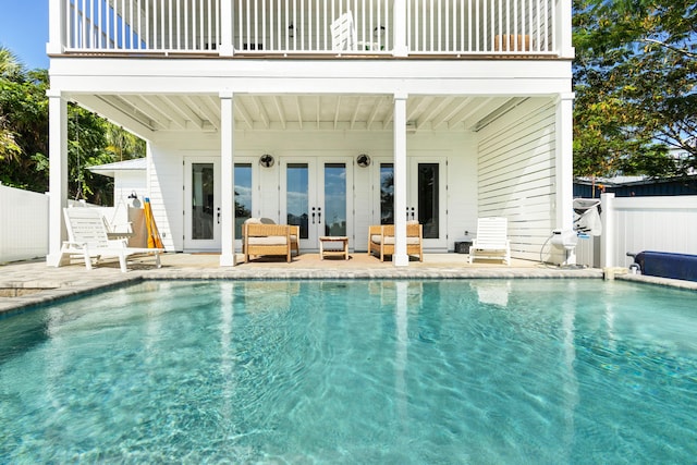 view of swimming pool featuring french doors, a patio, a fenced in pool, and fence