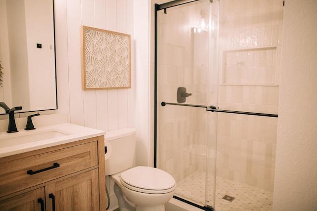 bathroom with toilet, a stall shower, and vanity