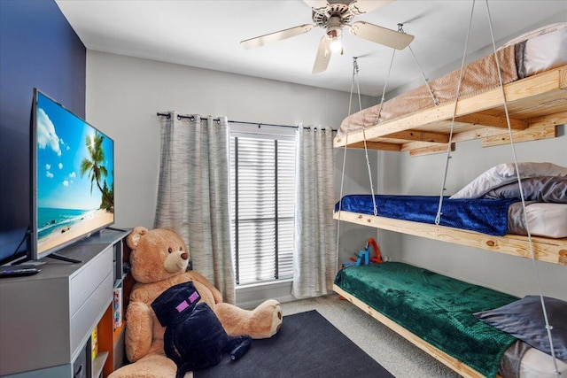 carpeted bedroom with ceiling fan and beamed ceiling