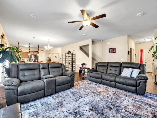 living room with hardwood / wood-style floors and ceiling fan with notable chandelier