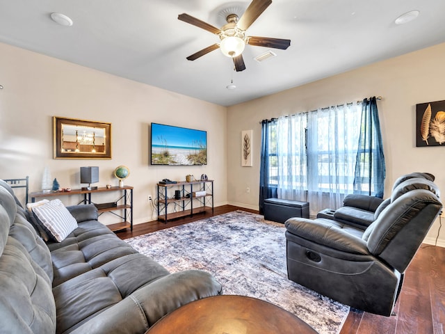 living room with ceiling fan and dark wood-type flooring