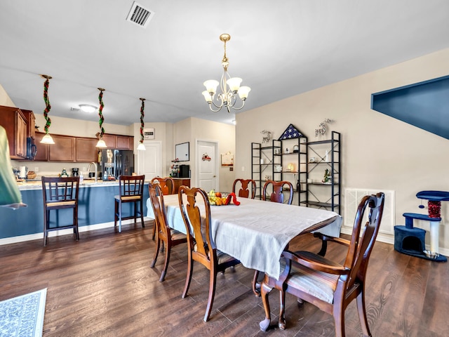 dining room with dark hardwood / wood-style flooring and a notable chandelier