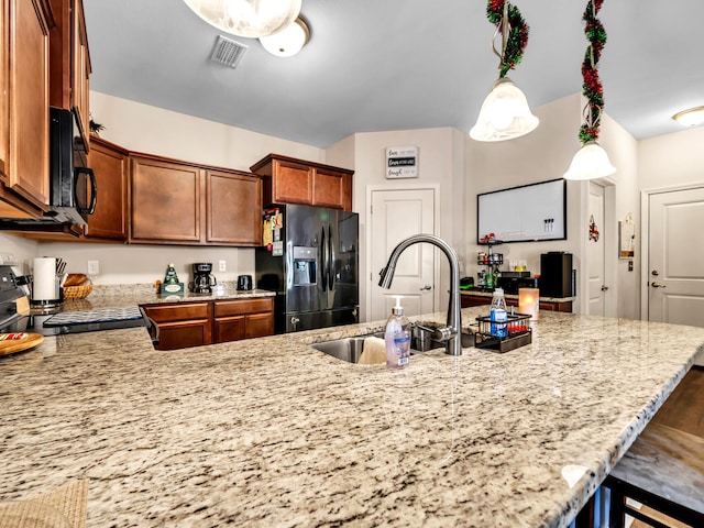 kitchen featuring sink, kitchen peninsula, decorative light fixtures, a breakfast bar, and black appliances