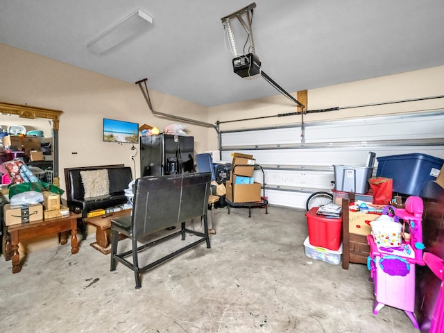 garage with a garage door opener and black fridge