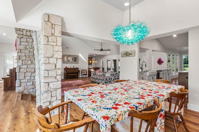 dining space featuring ceiling fan, high vaulted ceiling, and light hardwood / wood-style flooring