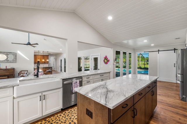 kitchen featuring white cabinets, appliances with stainless steel finishes, wood ceiling, vaulted ceiling, and a barn door