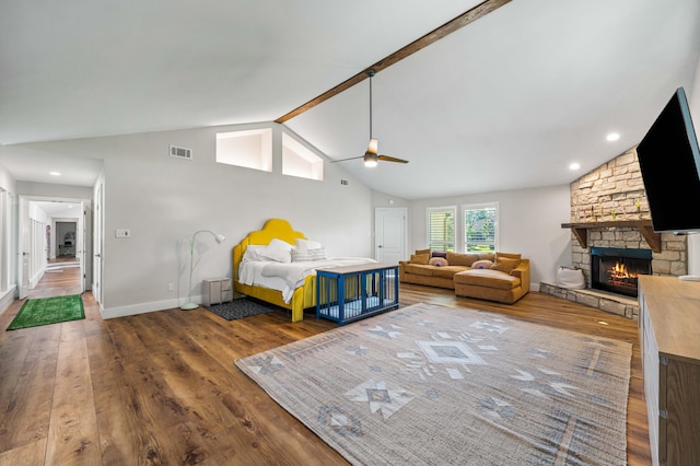 unfurnished bedroom featuring hardwood / wood-style flooring, lofted ceiling with beams, ceiling fan, and a fireplace