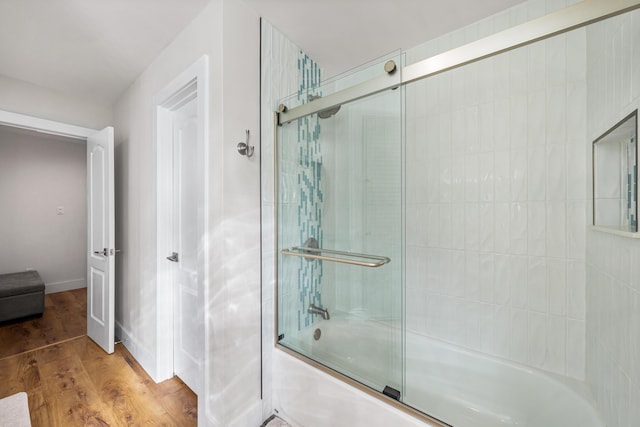 bathroom featuring wood-type flooring and enclosed tub / shower combo